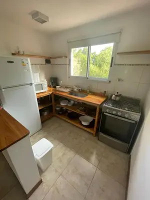 a kitchen with a white refrigerator and a sink at Casa terracota in Villa General Belgrano