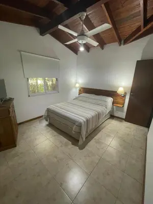 a bedroom with a bed and a ceiling fan at Casa terracota in Villa General Belgrano
