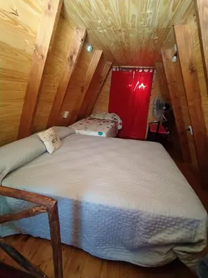 a bedroom with two beds in a wooden room at La Soñada in Santa Rosa de Calamuchita