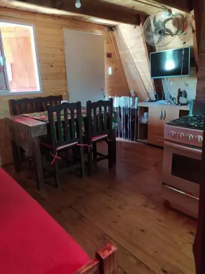 a kitchen with a table and chairs and a stove at La Soñada in Santa Rosa de Calamuchita