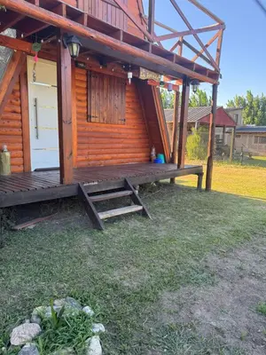 a log cabin with a porch and a deck at La Soñada in Santa Rosa de Calamuchita