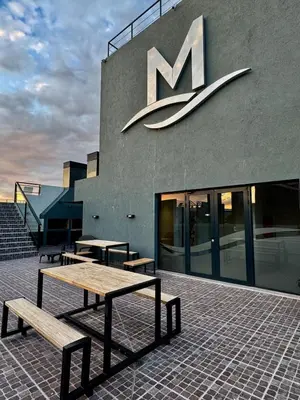 a building with a m sign on the side of it at Apart Miralejos 17 villa carlos Paz in Cordoba