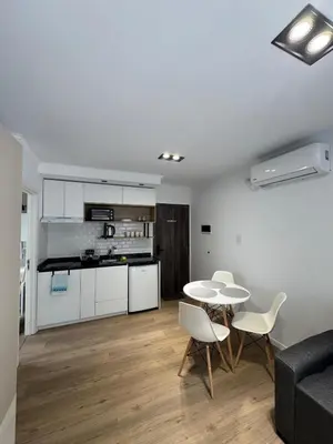 a living room with a table and chairs and a kitchen at Apart Miralejos 17 villa carlos Paz in Cordoba