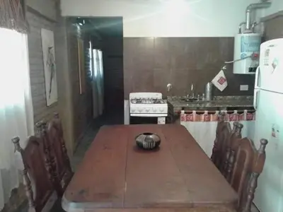 a kitchen with a wooden table and a stove at Paprikas in Villa Ciudad Parque