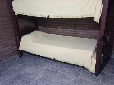a small bed in a brick room with a canopy at Paprikas in Villa Ciudad Parque