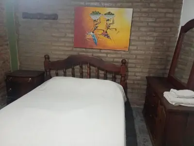 a bedroom with a bed and a painting on the wall at Paprikas in Villa Ciudad Parque