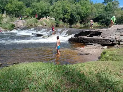a boy standing in the water in a river at Paprikas in Villa Ciudad Parque