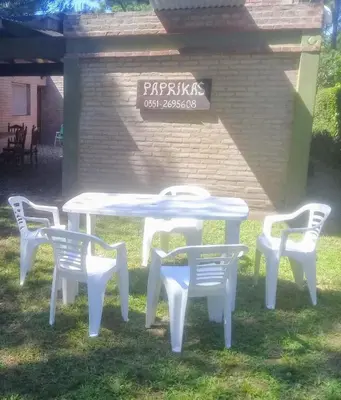 a white table and four chairs in the grass at Paprikas in Villa Ciudad Parque