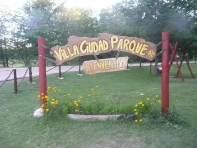 a sign for a park with flowers in the grass at Paprikas in Villa Ciudad Parque