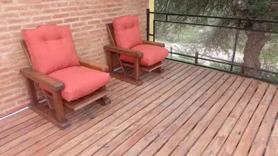 two chairs sitting on top of a deck at Cabaña los algarrobos in Mina Clavero