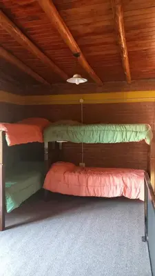 two bunk beds in a room with wooden ceilings at Cabaña los algarrobos in Mina Clavero