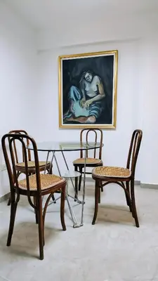 a table with two chairs and a painting on the wall at Patio Olmos a pasos in Cordoba
