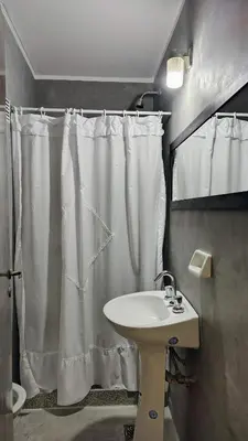 a bathroom with a white shower curtain and a sink at Patio Olmos a pasos in Cordoba