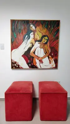 a painting on the wall next to two red stools at Patio Olmos a pasos in Cordoba