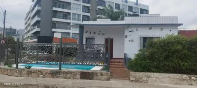 a house with a swimming pool in front of a building at DPTO ZONA centro in Villa Carlos Paz