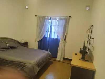 a bedroom with a bed and a desk with a television at DPTO ZONA centro in Villa Carlos Paz