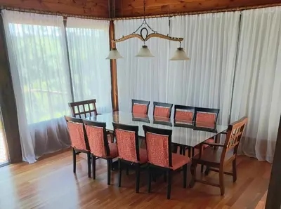 a dining room table and chairs in a room with windows at La Escondida, casa completa para 6 en Calamuchita in La Cruz
