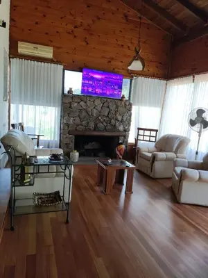 a living room with a stone fireplace and a tv at La Escondida, casa completa para 6 en Calamuchita in La Cruz