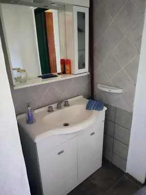 a bathroom with a white sink and a mirror at La Escondida, casa completa para 6 en Calamuchita in La Cruz