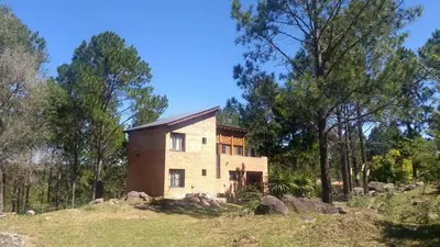 a house on top of a hill with trees at La Escondida, casa completa para 6 en Calamuchita in La Cruz