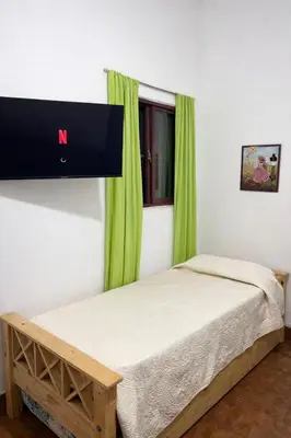 a bedroom with a bed with a tv on the wall at El Bosque de Simba - Casa in La Estancia