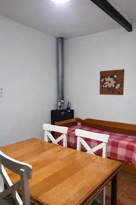 a room with two beds and a wooden table at El Bosque de Simba - Casa in La Estancia