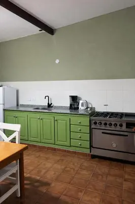 a kitchen with green cabinets and a stove at El Bosque de Simba - Casa in La Estancia