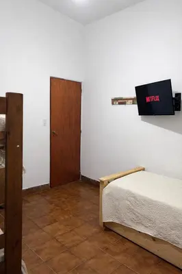 a bedroom with a bed and a tv on the wall at El Bosque de Simba - Casa in La Estancia