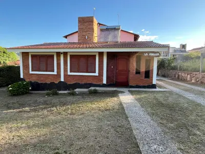 a small house with a red door on a street at La Soñada San Antonio de Arredondo in San Antonio de Arredondo