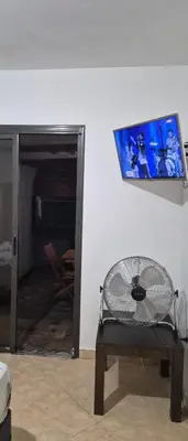 a room with a chair and a tv on the wall at Depto Bodhi Dorado in Villa Carlos Paz