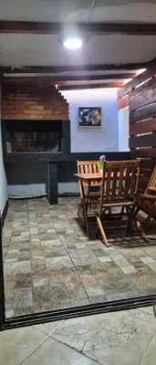 a room with two wooden benches and a fireplace at Depto Bodhi Dorado in Villa Carlos Paz