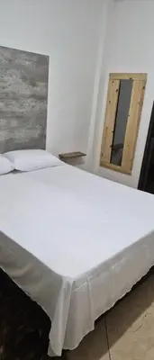 a large white bed in a room with a mirror at Depto Bodhi Dorado in Villa Carlos Paz