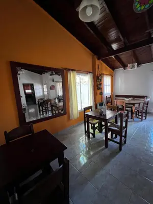 a dining room with tables and chairs and a mirror at Hosteria Abuelo Juan in Mina Clavero