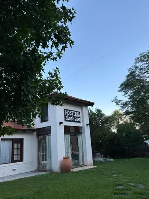 an old white building with a vase in the yard at Hosteria Abuelo Juan in Mina Clavero