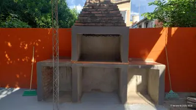a concrete bench in front of an orange wall at La Bonita, casa en Villa de Merlo, SL in Merlo