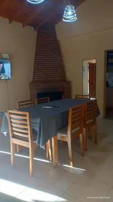 a dining room with a table and chairs and a fireplace at La Bonita, casa en Villa de Merlo, SL in Merlo