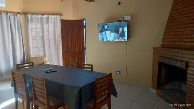 a dining room with a table and a fireplace at La Bonita, casa en Villa de Merlo, SL in Merlo