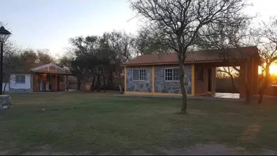 a house with a tree in front of a yard at Cabañas Antillanca in Luyaba