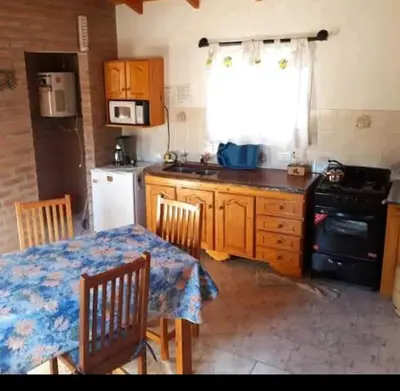 a kitchen with a table and a stove and a sink at Cabañas Antillanca in Luyaba