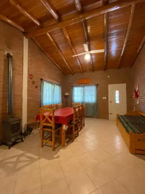 a room with a table and chairs and a stove at Cabañas Antillanca in Luyaba