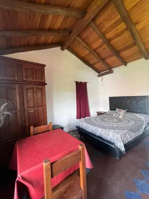 a bedroom with a bed and a table and chairs at Casa de iris in Mina Clavero