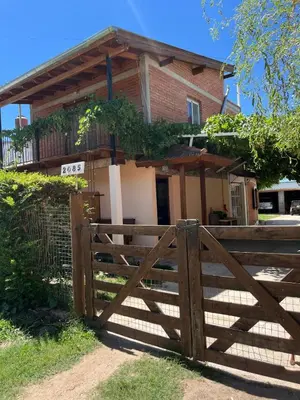 a wooden fence in front of a house at Deptos Mabelita in Mina Clavero