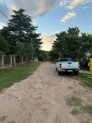 a white truck parked on the side of a dirt road at Casa en Villa Carlos Paz in Estancia Vieja