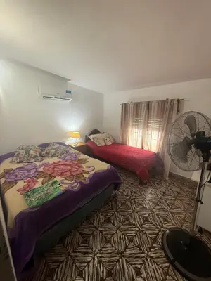a bedroom with two beds and a fan at Casa en Villa Carlos Paz in Estancia Vieja