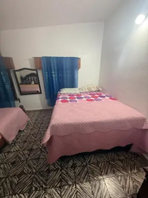 a bedroom with a bed with a pink blanket at Casa en Villa Carlos Paz in Estancia Vieja