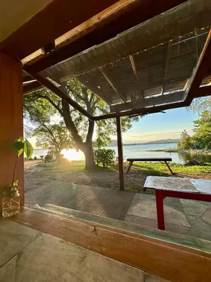 a patio with a picnic table and a view of the water at Casa del lago in Embalse