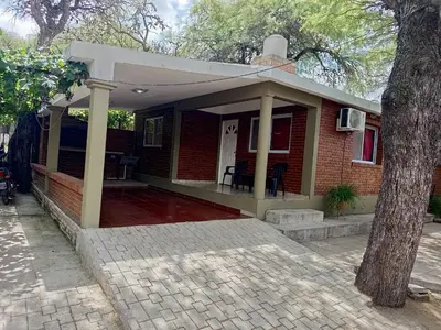 a small brick house with a front porch at Casa Agüero in Villa Cura Brochero
