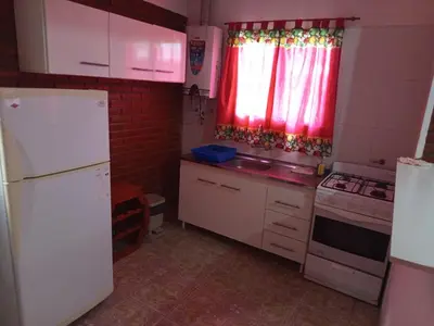 a kitchen with white cabinets and a white refrigerator at Casa Agüero in Villa Cura Brochero