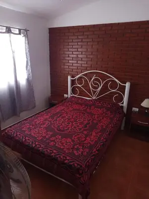a bed in a room with a brick wall at Casa Agüero in Villa Cura Brochero