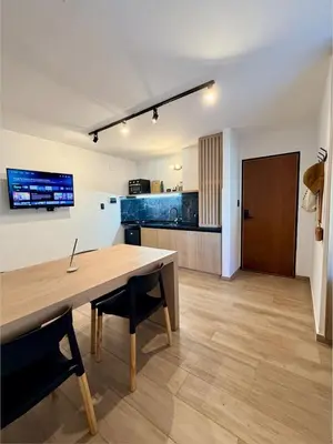 a dining room and kitchen with a wooden table and chairs at Apartment in Nueva Cba meters from Buen Pastor in Cordoba